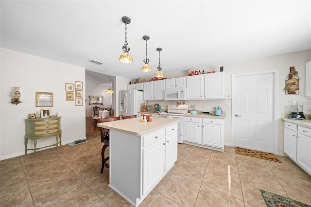 kitchen with a center island, white appliances, hanging light fixtures, white cabinetry, and a breakfast bar area