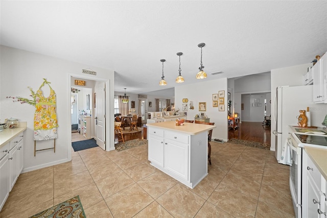 kitchen with white cabinets, hanging light fixtures, white electric range oven, a kitchen island, and a breakfast bar area