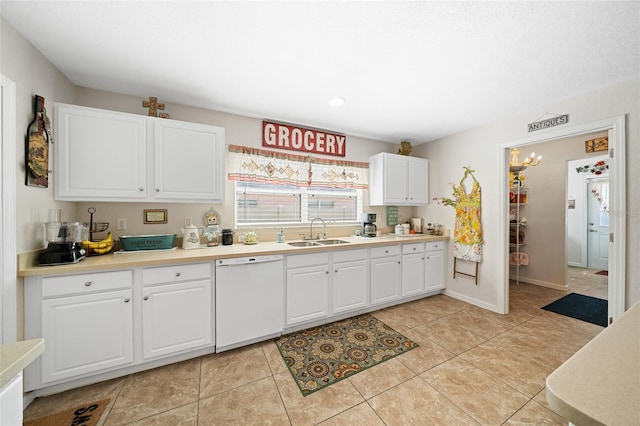 kitchen featuring white cabinets, light tile patterned floors, white dishwasher, and sink