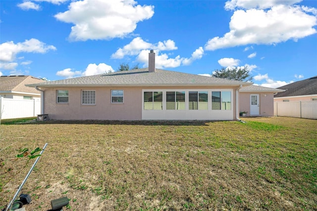 rear view of property with a yard