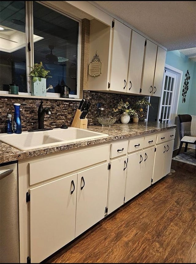 kitchen featuring white cabinetry, dark hardwood / wood-style flooring, sink, decorative backsplash, and dishwasher