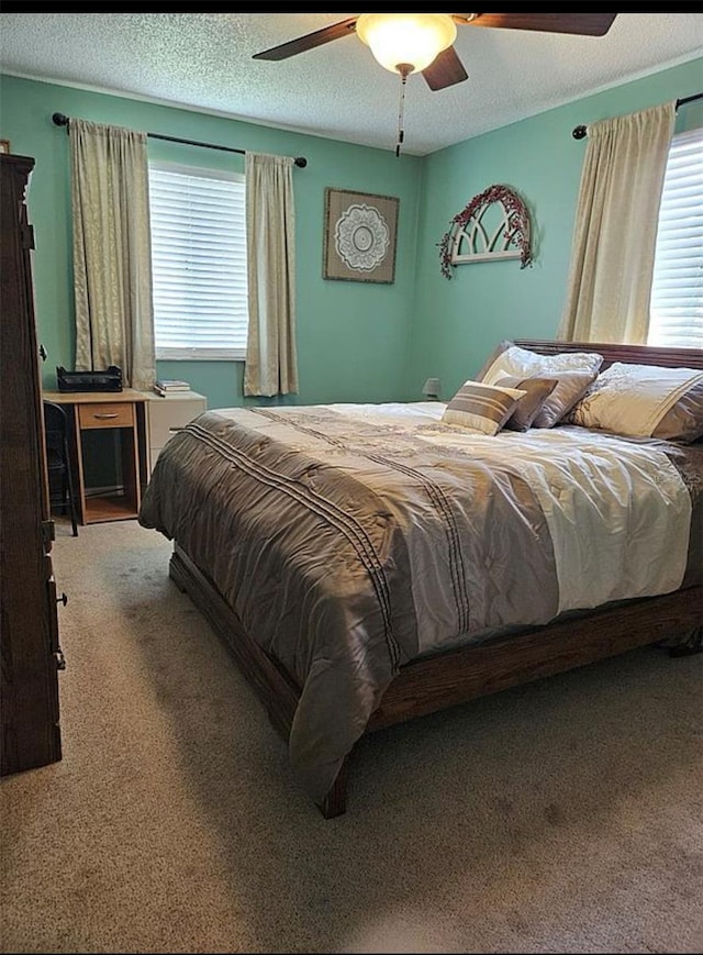 bedroom with a textured ceiling, carpet, and ceiling fan