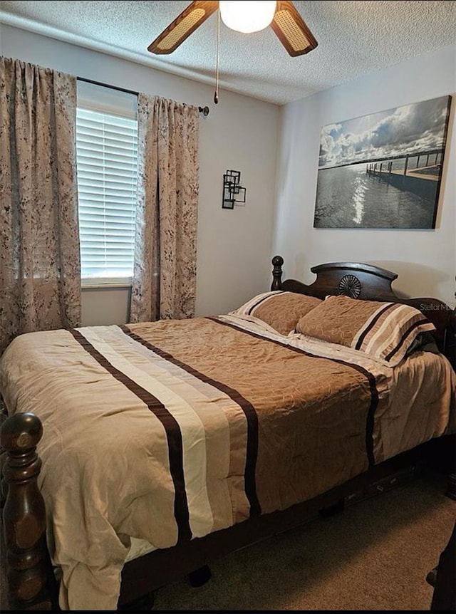 bedroom featuring ceiling fan, a textured ceiling, and carpet flooring