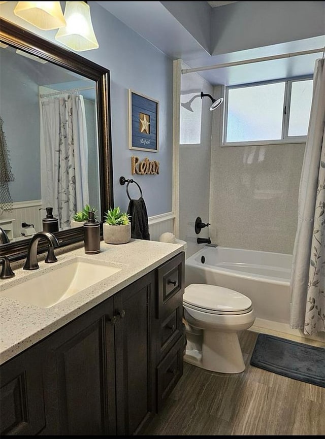 full bathroom featuring toilet, vanity, hardwood / wood-style flooring, and shower / bath combo with shower curtain