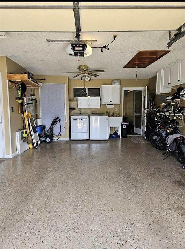 garage with ceiling fan, a garage door opener, separate washer and dryer, and sink