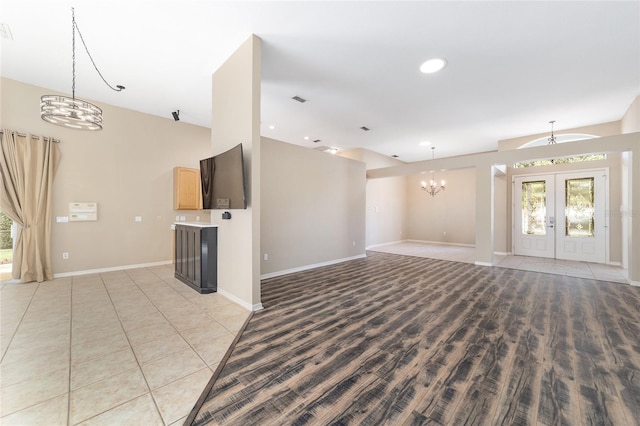 unfurnished living room featuring light tile patterned flooring and french doors