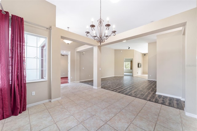 tiled empty room with a chandelier