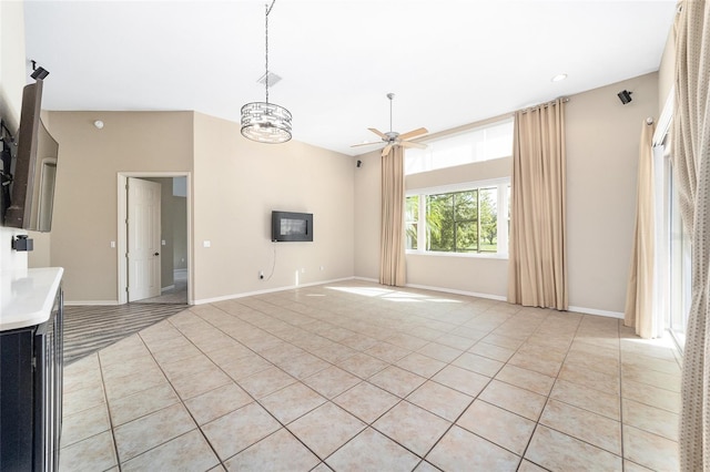 unfurnished living room featuring ceiling fan with notable chandelier and light tile patterned floors