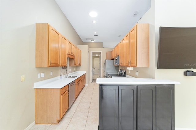 kitchen featuring kitchen peninsula, appliances with stainless steel finishes, sink, and light tile patterned floors