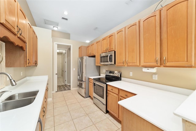 kitchen with stainless steel appliances, sink, and light tile patterned flooring