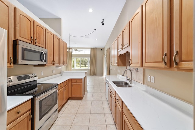 kitchen with appliances with stainless steel finishes, sink, ceiling fan, and light tile patterned flooring