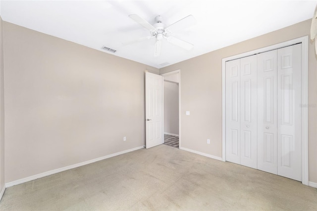 unfurnished bedroom with a closet, light carpet, and ceiling fan