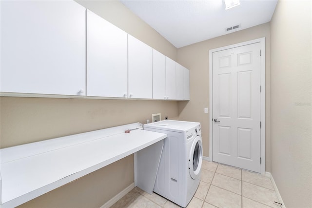 clothes washing area featuring cabinets, washing machine and clothes dryer, and light tile patterned flooring