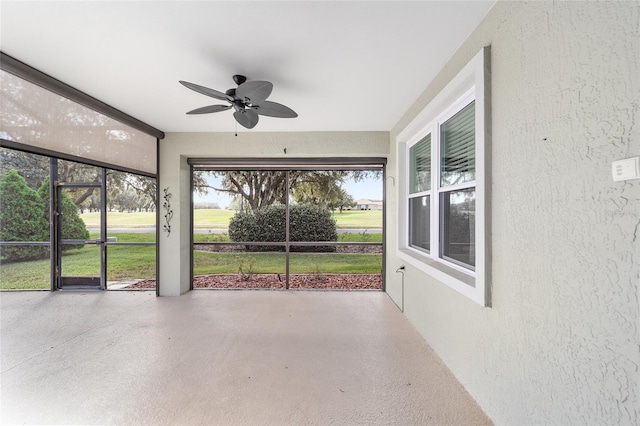 unfurnished sunroom with ceiling fan