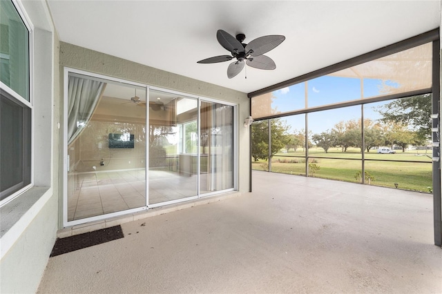 unfurnished sunroom featuring ceiling fan