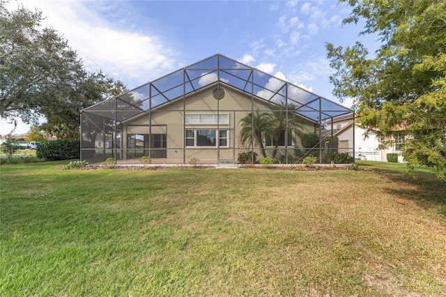 back of house with a lanai and a yard