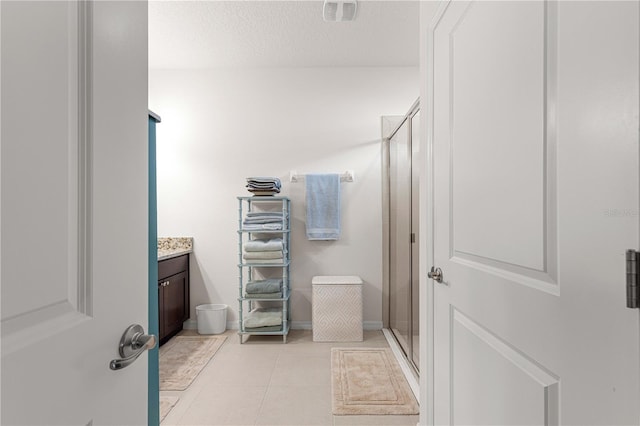 bathroom with vanity, tile patterned floors, an enclosed shower, and a textured ceiling