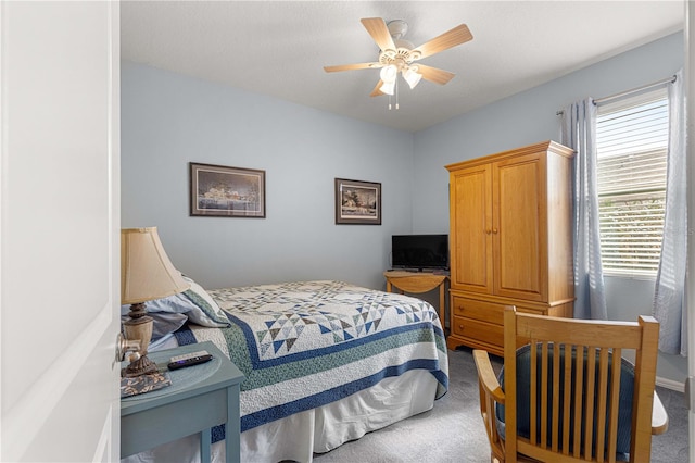 carpeted bedroom featuring a textured ceiling and ceiling fan