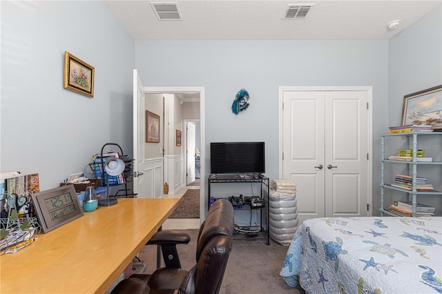 carpeted bedroom with a textured ceiling and a closet