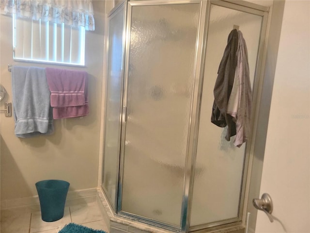 bathroom featuring a shower with shower door and tile patterned floors