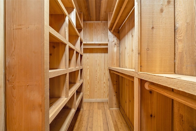 wine cellar with wood walls and light hardwood / wood-style flooring