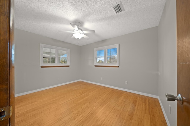 unfurnished room featuring ceiling fan, light hardwood / wood-style flooring, and a textured ceiling