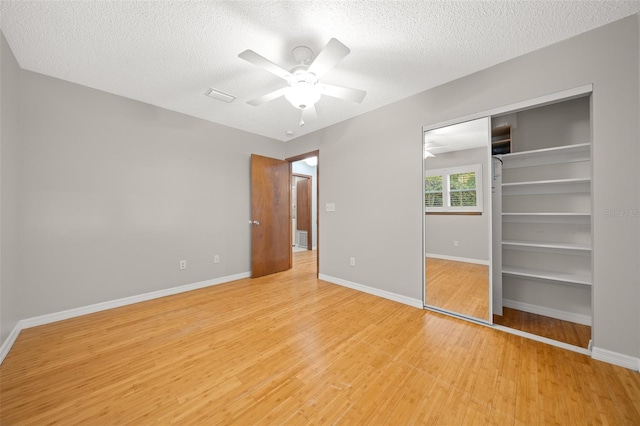 unfurnished bedroom featuring ceiling fan, a textured ceiling, and light wood-type flooring