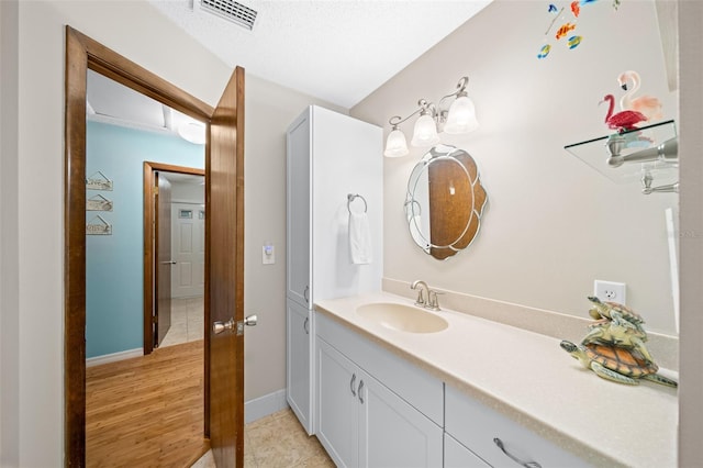 bathroom featuring hardwood / wood-style floors, vanity, and a textured ceiling