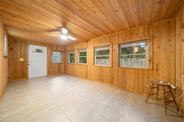 unfurnished sunroom with ceiling fan, wooden ceiling, and a wealth of natural light