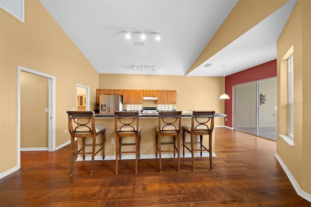 11700 SW 72nd Cir, Ocala, FL 34476 - kitchen with stainless steel refrigerator with ice dispenser, a breakfast bar area, dark wood finished floors, range, and high vaulted ceiling