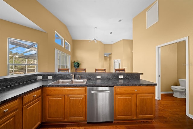 kitchen featuring dark wood-style floors, dark countertops, a sink, and brown cabinets