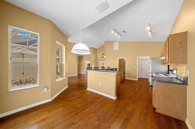 kitchen featuring dark countertops, visible vents, dark wood-type flooring, vaulted ceiling, and baseboards