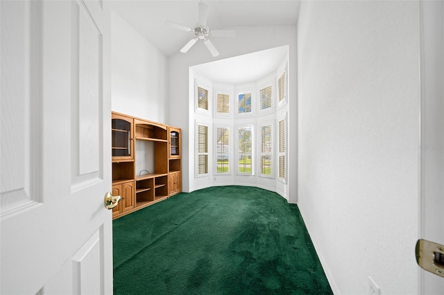 interior space with ceiling fan, high vaulted ceiling, dark carpet, and baseboards