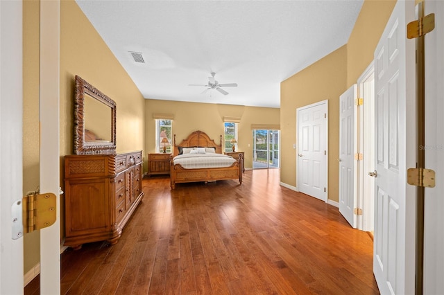 bedroom with a ceiling fan, baseboards, visible vents, and hardwood / wood-style floors