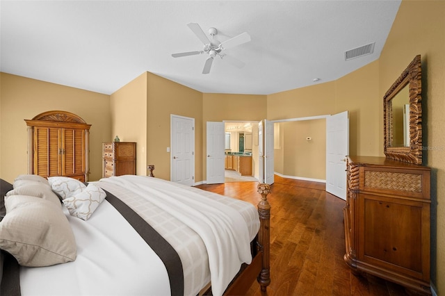 bedroom with ceiling fan, connected bathroom, visible vents, baseboards, and dark wood finished floors