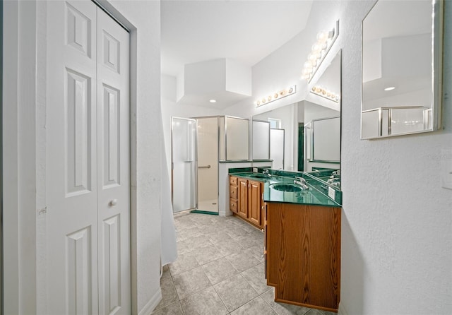 full bath with a closet, tile patterned flooring, vanity, and a stall shower