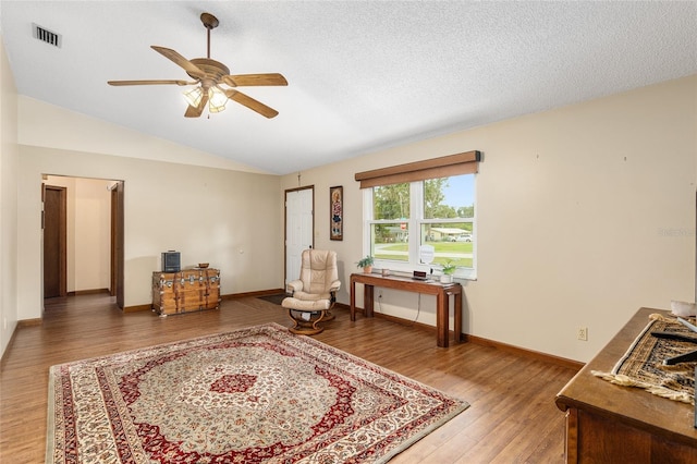 sitting room with ceiling fan, wood-type flooring, a textured ceiling, and vaulted ceiling