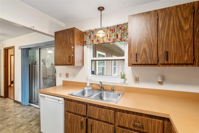 kitchen featuring a textured ceiling, decorative light fixtures, sink, and white dishwasher