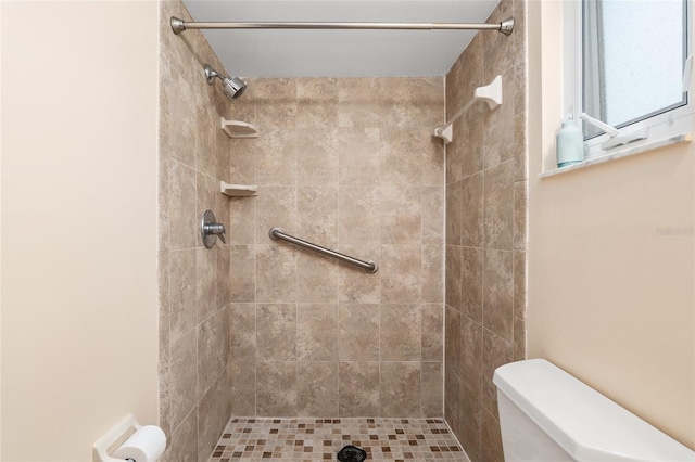 bathroom featuring toilet and tiled shower