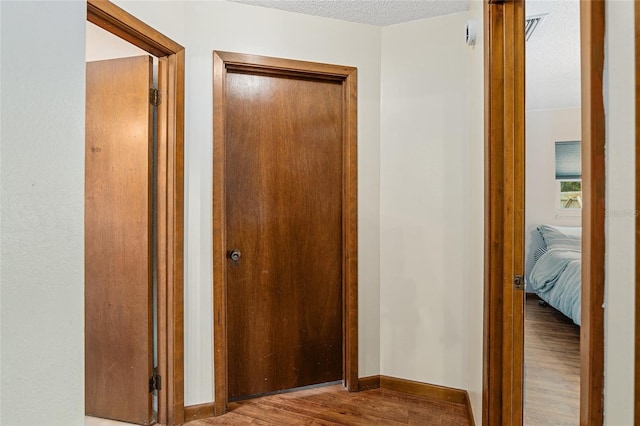 corridor featuring hardwood / wood-style floors and a textured ceiling