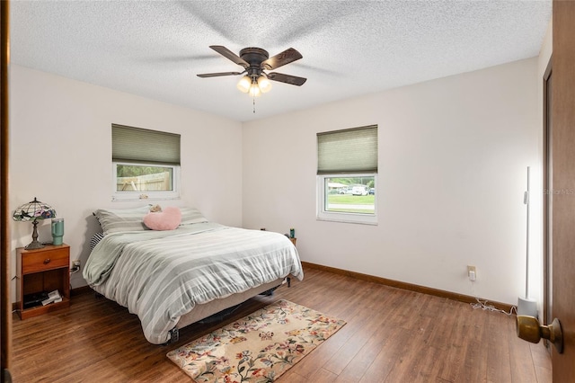 bedroom with ceiling fan, wood-type flooring, and a textured ceiling