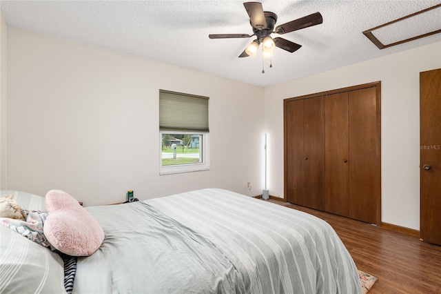 bedroom with a closet, a textured ceiling, hardwood / wood-style flooring, and ceiling fan