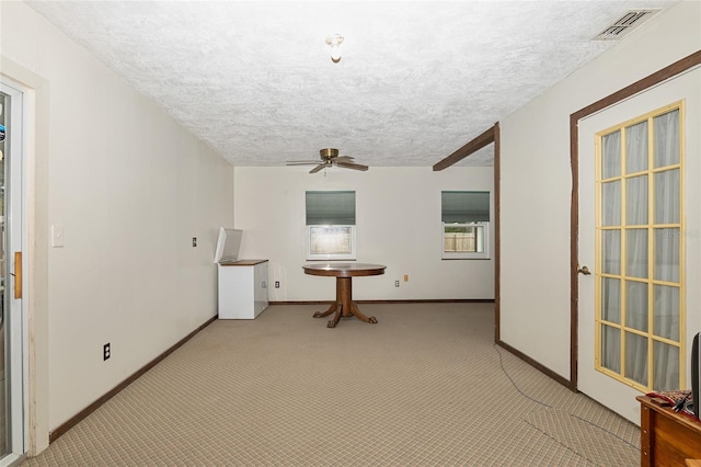 carpeted empty room with a textured ceiling and ceiling fan