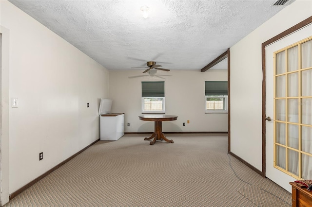 unfurnished room featuring a textured ceiling, light colored carpet, and ceiling fan