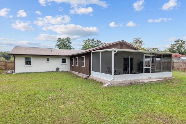 back of property featuring a lawn and a sunroom