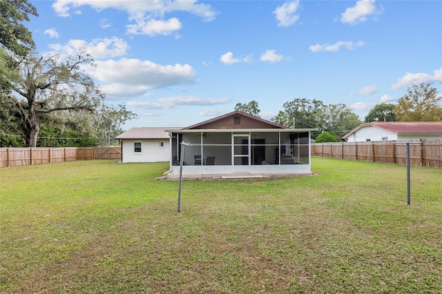 back of property with a lawn and a sunroom