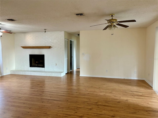 unfurnished living room with a fireplace, hardwood / wood-style floors, and a textured ceiling