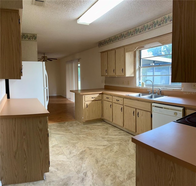 kitchen with white appliances, sink, ceiling fan, a textured ceiling, and kitchen peninsula