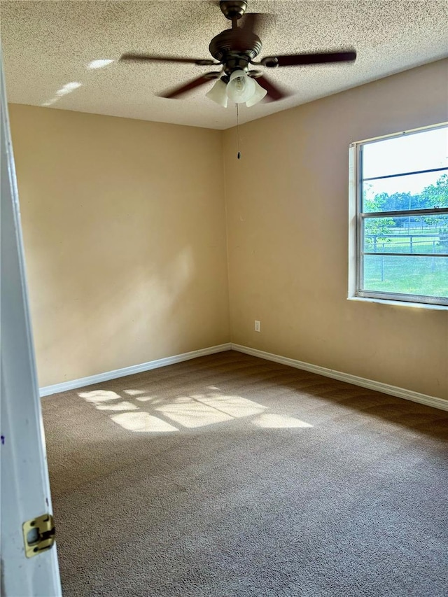 carpeted spare room featuring a textured ceiling and ceiling fan