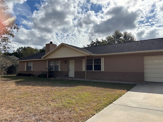 ranch-style home featuring a garage and a front lawn